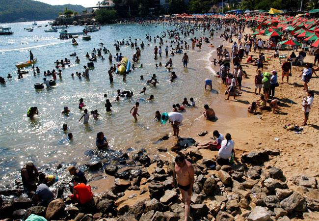 Vacacionistas nadan en playas contaminadas