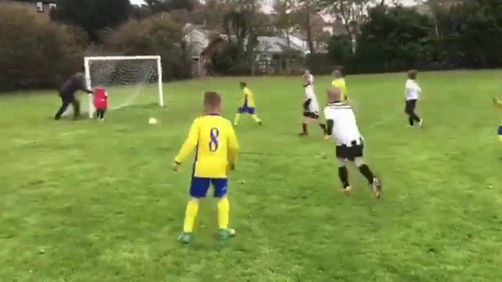 El padre que empuja a su hijo para que detenga un gol en un partido de fútbol infantil